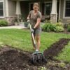 Garden Cultivator In Use - Soil Loosening Woman using manual garden cultivator to loosen soil in home garden bed